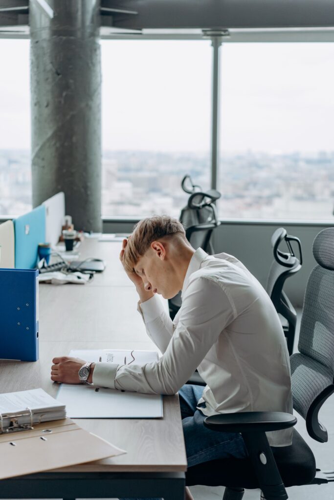 Office worker with tech neck in Palm Harbor hunched over a desk from poor posture